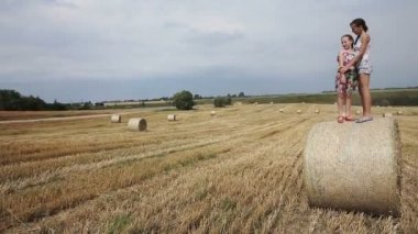 Samanlık üzerinde duran iki kız.