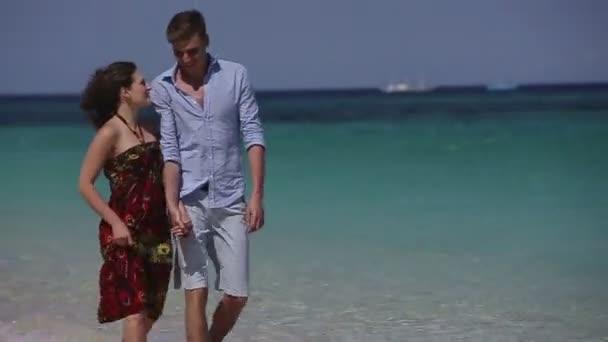 Couple walk together along the beach — Stock Video