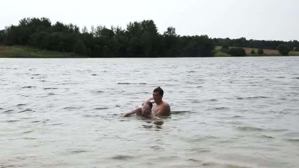 Man teaching girl how to swim. — Stock Video