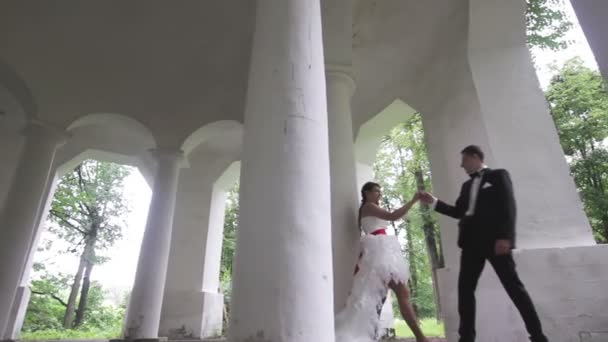 Novia y novio bailando en las antiguas columnas . — Vídeos de Stock