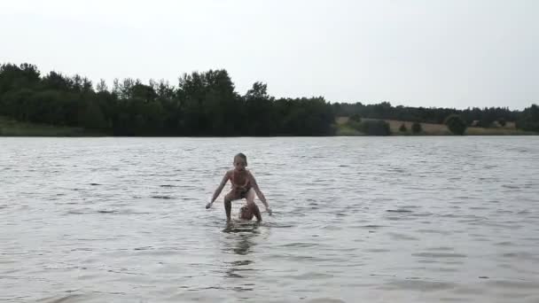 Père et sa petite fille s'amusent sur le lac — Video