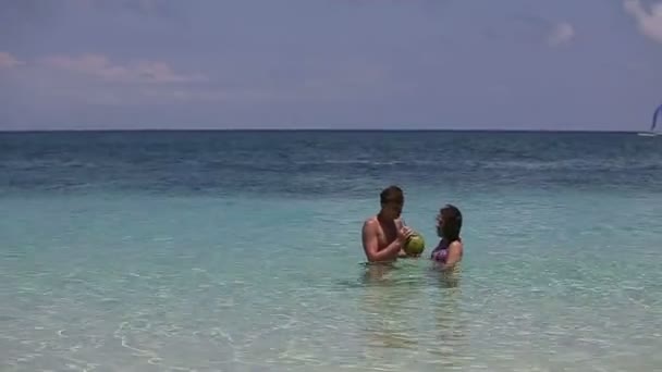 Счастливая пара на пляже с кокосом — стоковое видео