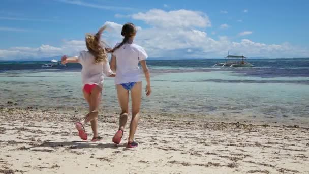 Chicas sonrientes salpicando y corriendo en el mar . — Vídeos de Stock