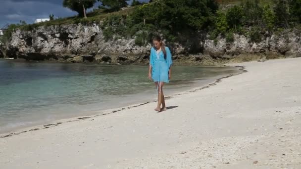 Молода дівчина гуляє уздовж пляжу . — стокове відео
