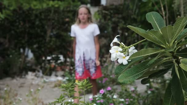 Ung flicka att lukta blomma på gren — Stockvideo