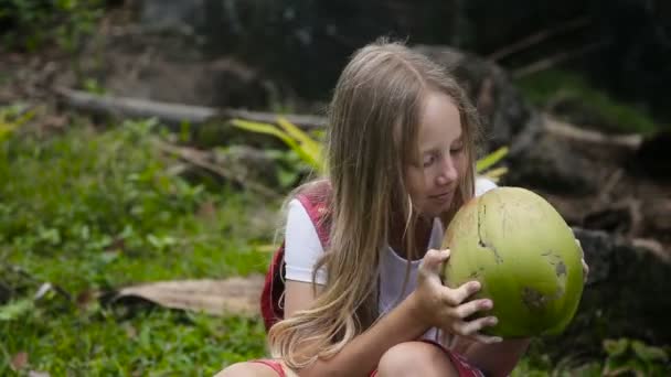 Jong meisje speelt met kokos — Stockvideo