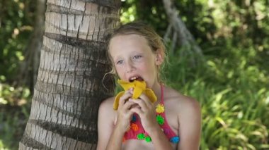 Young girl eating mango fruit