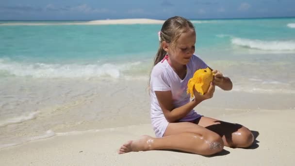 Young girl on the beach eating mango fruit — Stock Video