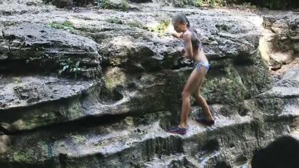 Yong girl climbs on rock — Αρχείο Βίντεο