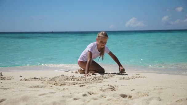 Šťastné dítě hraje s pískem na pláži v létě. — Stock video