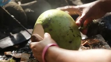 woman opening coconut with big knife
