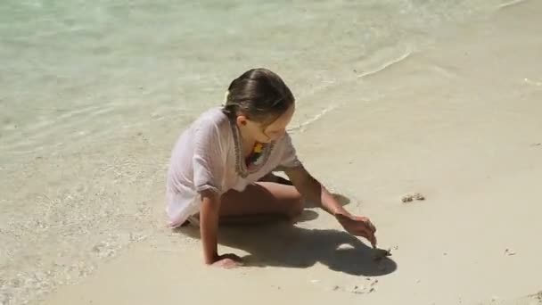 Lyckligt barn leker med sand på stranden på sommaren. — Stockvideo