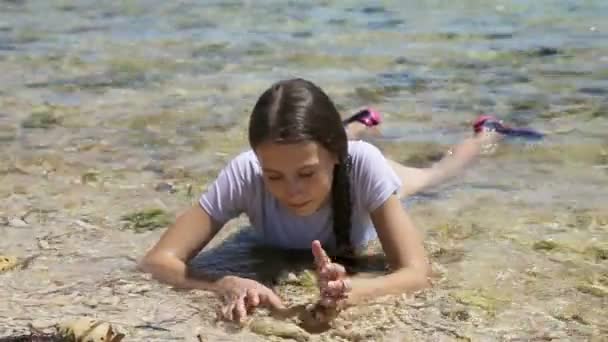Счастливый ребенок играет с песком на пляже летом . — стоковое видео