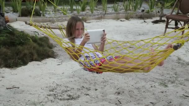 Девушка в гамаке с табличкой на пляже — стоковое видео