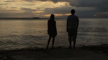 Çift sahilde günbatımı siluet