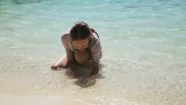 Happy child playing with sand on beach in summer. — Stock Video