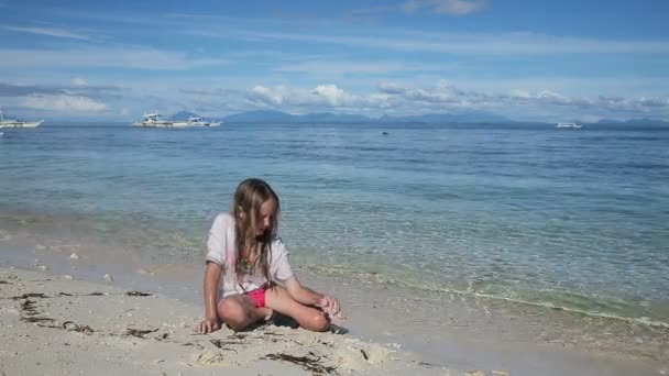 Lyckligt barn leker med sand på stranden på sommaren. — Stockvideo