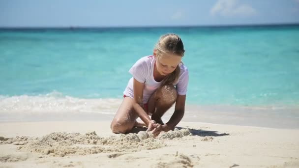 Lyckligt barn leker med sand på stranden på sommaren. — Stockvideo