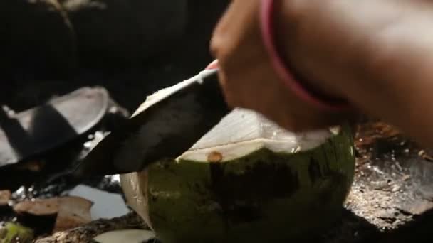 Frau öffnet Kokosnuss mit großem Messer — Stockvideo