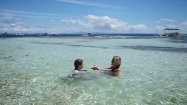 Anne ve kızı tropikal deniz oynarken