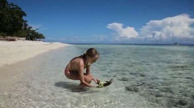 Oyuncak gemi ile sahilde oynarken Yuong kız