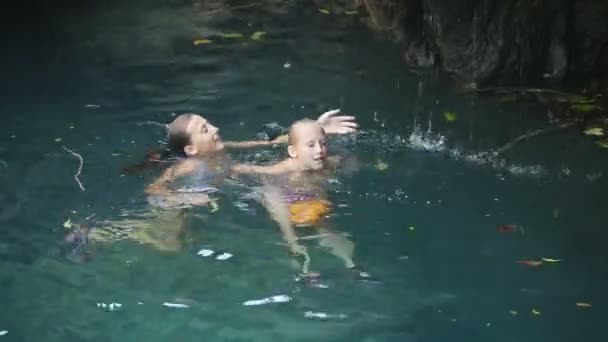 Young girl swimming in a waterfall — Stock Video