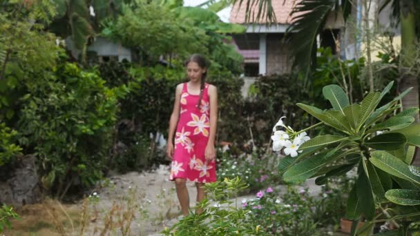 युवा लड़की शाखा पर फूल सुगंधित — स्टॉक वीडियो