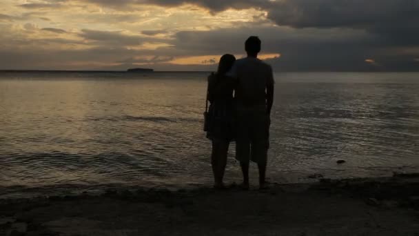 Zonsondergang silhouet van het paar op het strand — Stockvideo