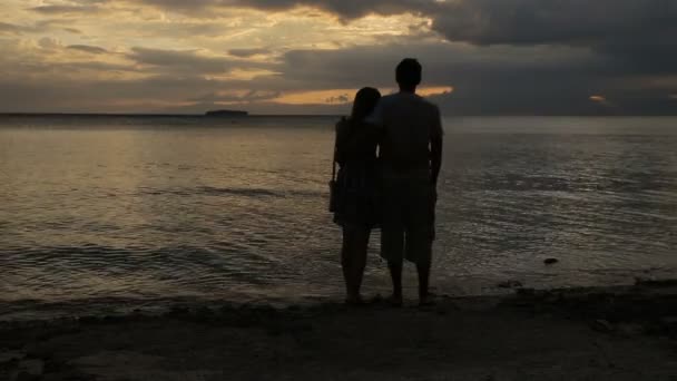 Silueta del atardecer de pareja en la playa — Vídeos de Stock