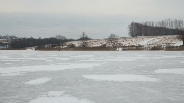 Семейное катание на коньках по замёрзшему озеру — стоковое видео