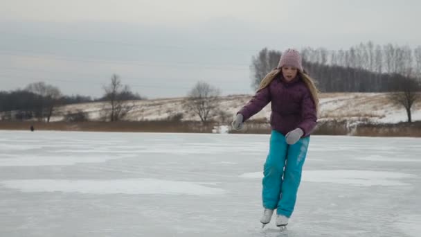Jong meisje schaatsen op de bevroren meer — Stockvideo