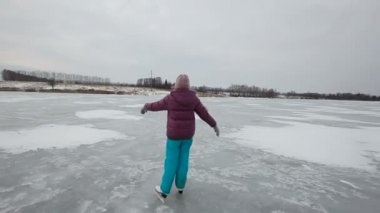 Genç kız buz donmuş gölde buz pateni