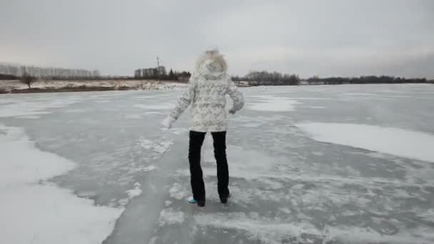 Jeune fille patinage sur glace lac gelé — Video