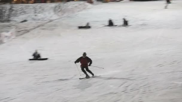 Esquiadores y snowboarders esquiando cuesta abajo — Vídeo de stock