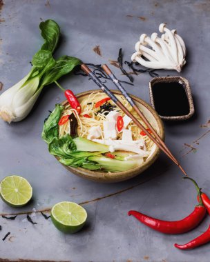 Japon kase ramen çorba tofu peyniri, erişte, bok choi, smimeji deniz yosunu, biber ve limon ile turkuaz çubuklarla metal masa üzerinde görev yaptı. Karanlık rustik tarzı. Top vie