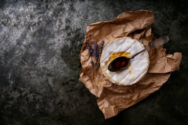 Fransız peynirli Camembert kaşık bal ve kurutulmuş lavanta kökleri koyu kırsal arka planda. Üst Manzara. Boşluğu kopyala
