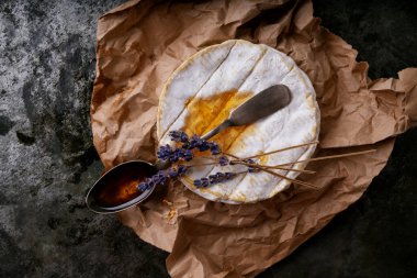 Fransız peynirli Camembert kaşık bal ve kurutulmuş lavanta kökleri koyu kırsal arka planda. Üst Manzara. Kapat.