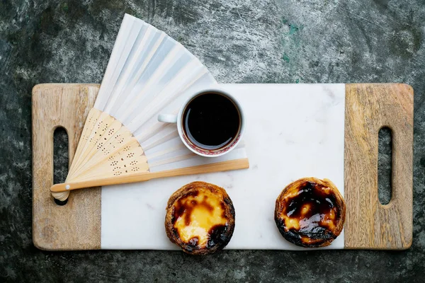 帕塞尔 纳塔传统的葡萄牙甜点 蛋挞与一杯芬芳的咖啡与乡村背景装饰东方风扇板 顶部视图 — 图库照片