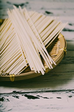 Geleneksel Asya kuru eriştesi bambu hasırının üzerinde. Asya malzemeleri konsepti. Kırsal biçim