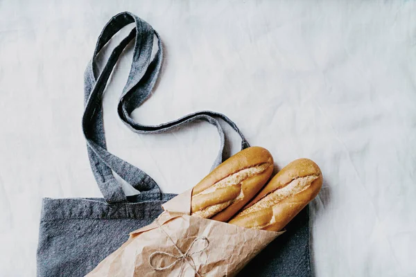 Baguette Tradizionale Francese Uno Sfondo Tessile Blu Riciclato Avvolto Carta — Foto Stock