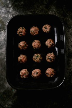 Siyah seramik tepside köfte pişirmeye hazır. Düz Yat. Üst Görünüm