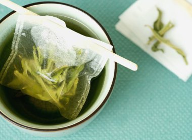 Bir fincanda limon Verbena çayı, el yapımı çay poşeti ve tidewater yeşili bir arka plan. Üst Manzara. Düz Yat
