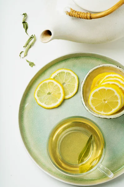 Lemon Verbena tea served with lemon, decorated with verbena dry leaves with vintage teapot. Flat Lay. Top View