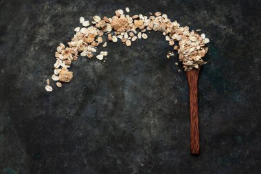 Tahta hindistan cevizi kaşığının içindeki müsli kırsal metal bir zemine yayılmış. Üst Manzara. Düz Yat