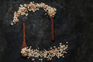 Tahta hindistan cevizi kaşıklarıyla müsli ve tahtadan yapılmış metal bir arka plana yayılmış. Üst Manzara. Düz Yat