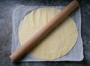 Kağıt üzerinde merdaneyle hamuru pişirmeye hazır. Hazırlık süreci. Üst Manzara. Düz Yat