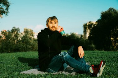 Yalnız, yalnız, orta yaşlı bir adam parkta kahve içiyor. Yalnızlık kavramı, sosyal uzaklık ve kendi kendine insalsiyon. Ruhsal sağlık kavramı, doğaya bağlıdır.