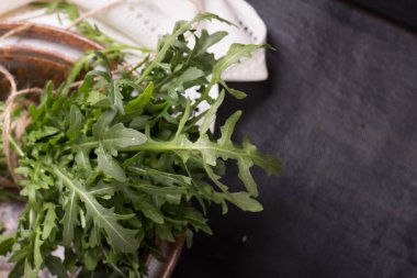 Beyaz bir na ile kahverengi vintage seramik tabak içinde taze Ruccola