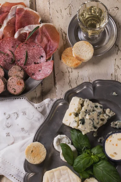 Un conjunto de varios quesos y carnes franceses e italianos en el vino — Foto de Stock