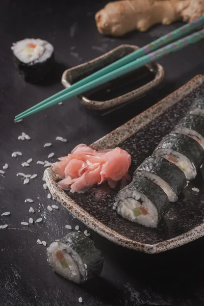 Maki-Sushi-Röllchen mit Lachs und Avocado auf dem alten Japaner — Stockfoto